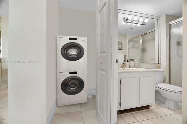 clothes washing area featuring stacked washer / drying machine, light tile patterned floors, and sink