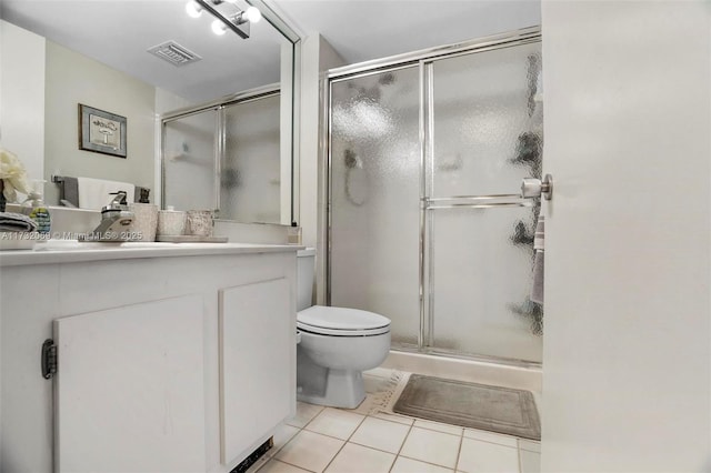 bathroom featuring vanity, toilet, a shower with shower door, and tile patterned flooring