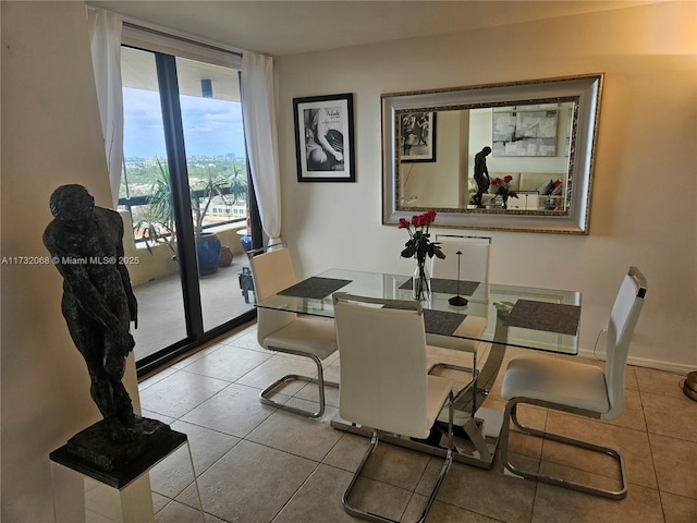 dining room with a wall of windows and light tile patterned floors