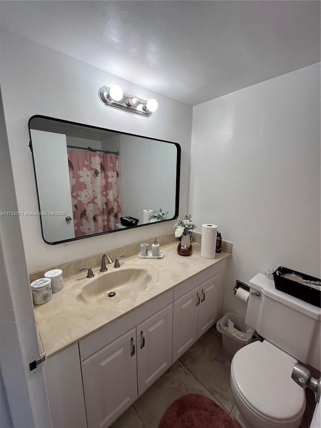 bathroom featuring vanity, toilet, and tile patterned flooring