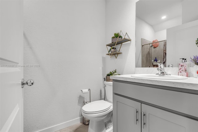 bathroom featuring tile patterned flooring, vanity, a shower, and toilet