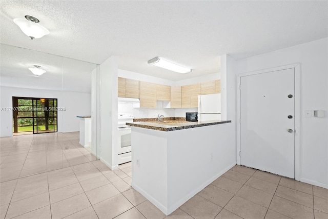 kitchen with sink, light tile patterned floors, kitchen peninsula, light brown cabinets, and white appliances