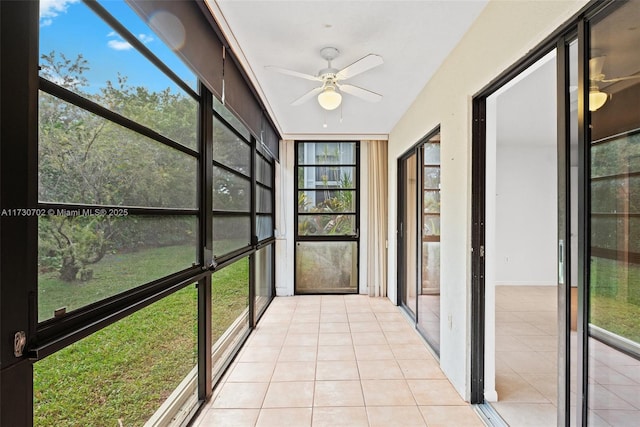 unfurnished sunroom with ceiling fan and plenty of natural light