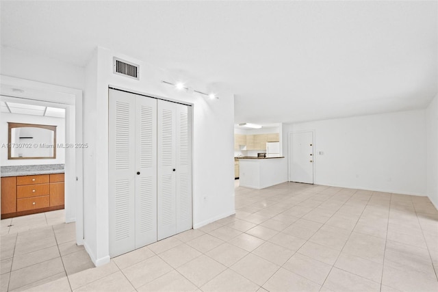 interior space featuring white refrigerator, a closet, and light tile patterned floors