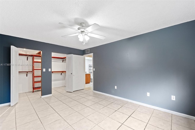 tiled spare room featuring a textured ceiling and ceiling fan