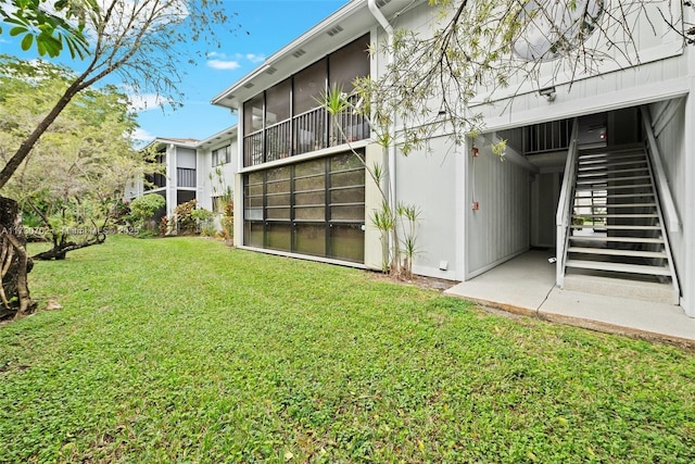 back of property featuring a lawn and a sunroom