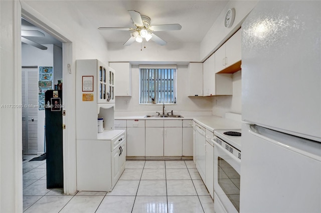 kitchen featuring sink, white cabinets, light tile patterned floors, ceiling fan, and white appliances