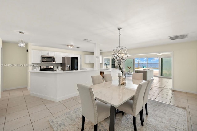 dining room with a chandelier, light tile patterned floors, visible vents, and baseboards