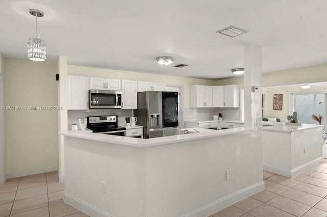 kitchen featuring white cabinets, appliances with stainless steel finishes, a peninsula, hanging light fixtures, and light countertops