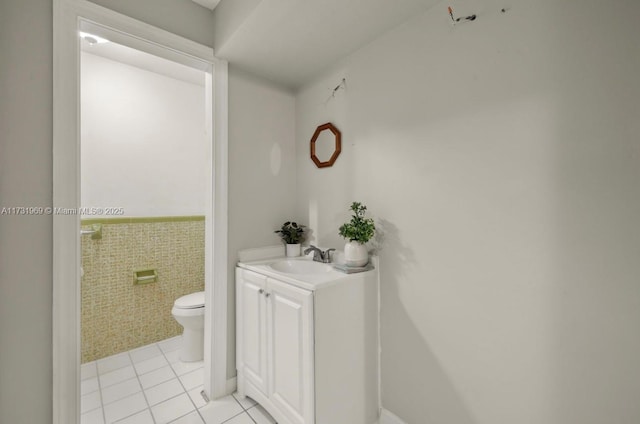 bathroom featuring tile walls, toilet, wainscoting, vanity, and tile patterned flooring