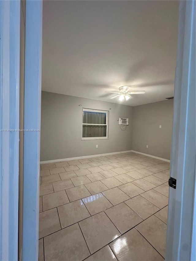 unfurnished room featuring light tile patterned floors, a wall unit AC, and ceiling fan