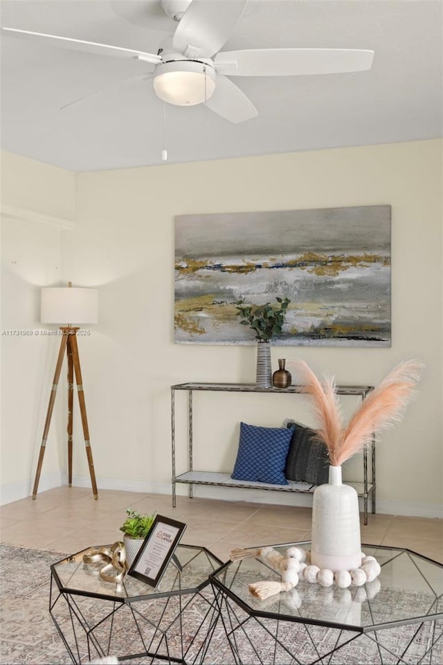 sitting room with ceiling fan, baseboards, and light tile patterned floors