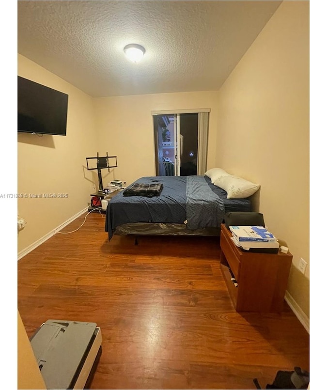 bedroom featuring hardwood / wood-style flooring and a textured ceiling