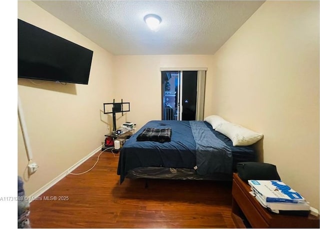 bedroom featuring a textured ceiling and dark hardwood / wood-style flooring