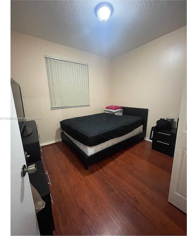 bedroom with hardwood / wood-style floors and a textured ceiling