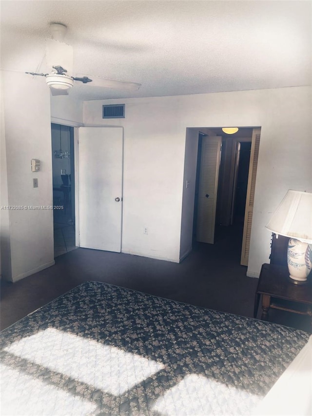 unfurnished bedroom featuring ceiling fan and a textured ceiling