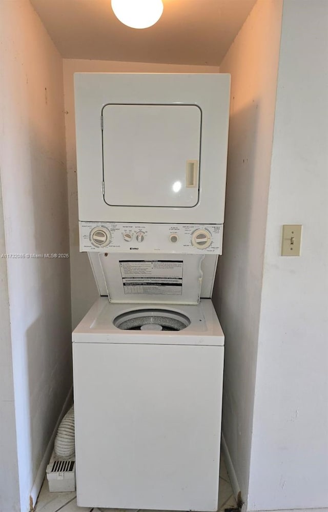 clothes washing area featuring stacked washing maching and dryer