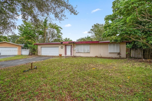 ranch-style home with a garage and a front lawn