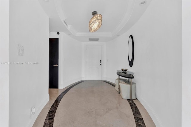 hallway featuring crown molding and a tray ceiling