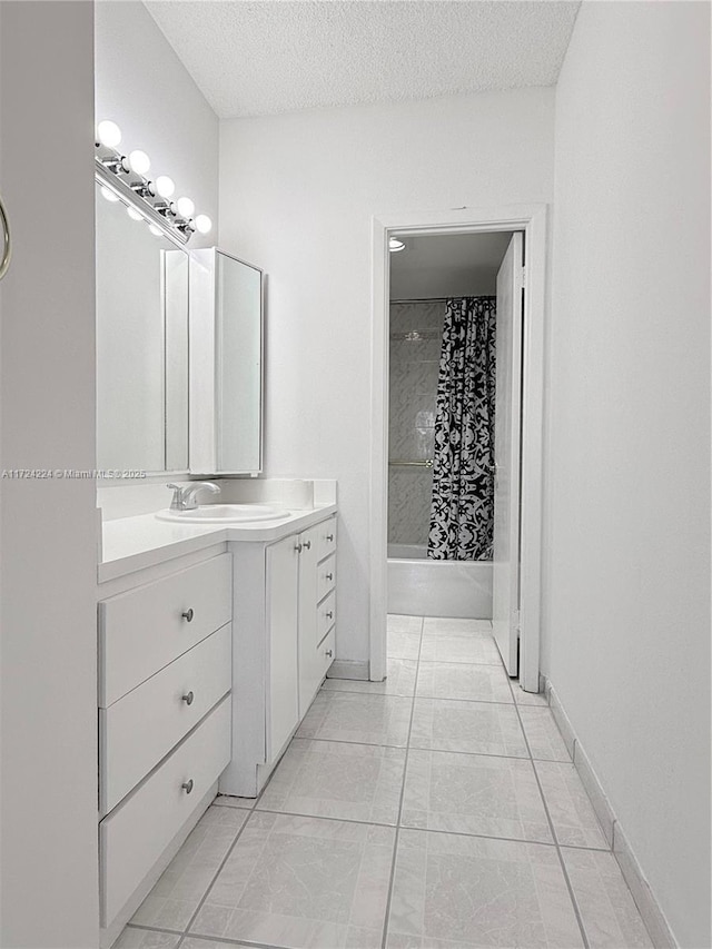 bathroom with vanity, shower / tub combo with curtain, and a textured ceiling