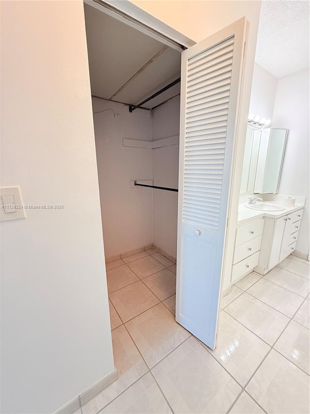 walk in closet with sink and light tile patterned floors