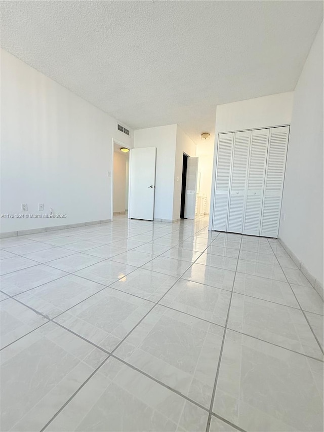 unfurnished bedroom with a textured ceiling and a closet