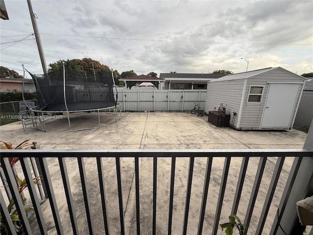 view of yard with a storage unit, a trampoline, and a patio area