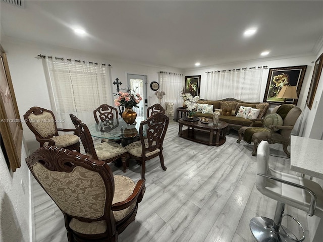 dining area featuring crown molding and light wood-type flooring