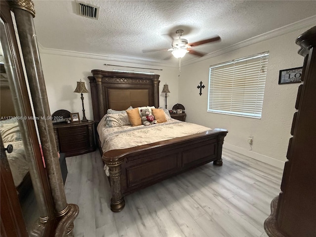 bedroom featuring a textured ceiling, light hardwood / wood-style flooring, ornamental molding, and ceiling fan