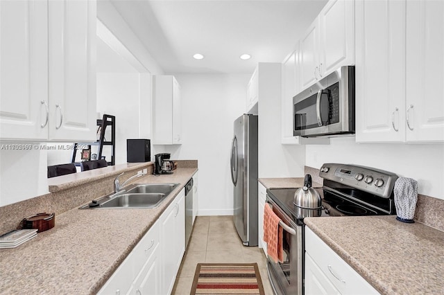 kitchen with sink, light tile patterned floors, white cabinets, and appliances with stainless steel finishes