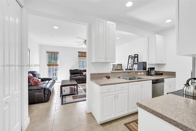 kitchen with sink, white cabinets, stainless steel dishwasher, light tile patterned floors, and ceiling fan