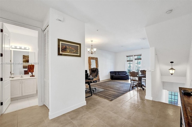 corridor featuring light tile patterned flooring, an inviting chandelier, and sink