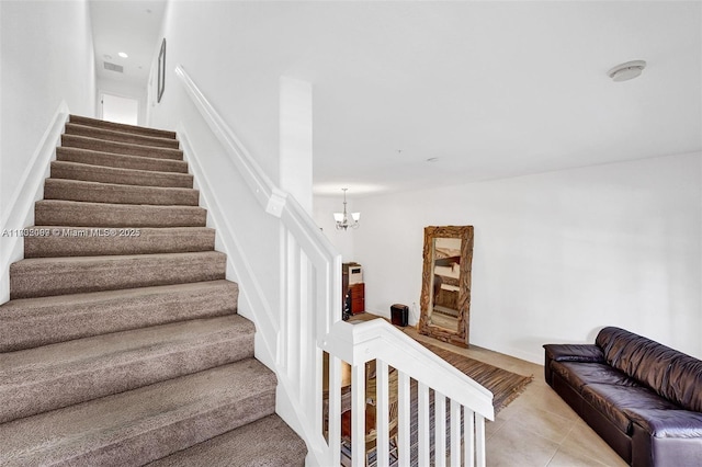 stairway with tile patterned flooring and a notable chandelier