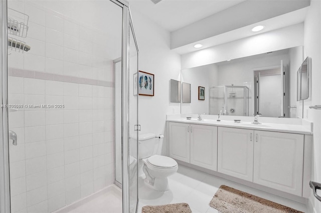 bathroom featuring vanity, a shower with shower door, and toilet