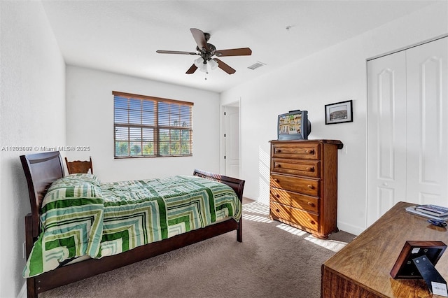 carpeted bedroom with ceiling fan and a closet