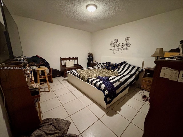 tiled bedroom featuring a textured ceiling