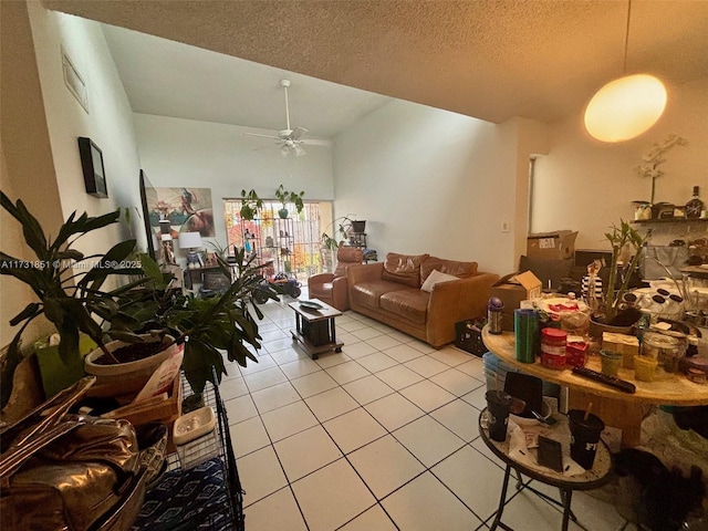 tiled living room with ceiling fan, high vaulted ceiling, and a textured ceiling