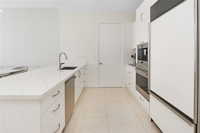 kitchen with white cabinetry, appliances with stainless steel finishes, light stone countertops, and sink