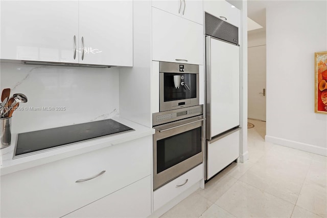 kitchen with black electric stovetop, white cabinets, paneled fridge, and stainless steel oven