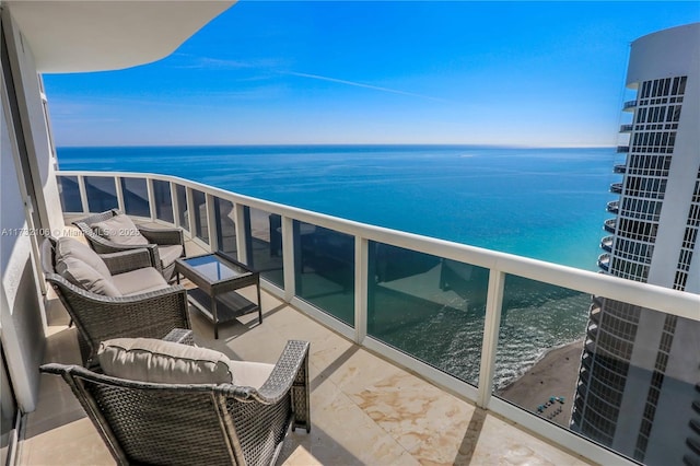 balcony with a water view and a view of the beach