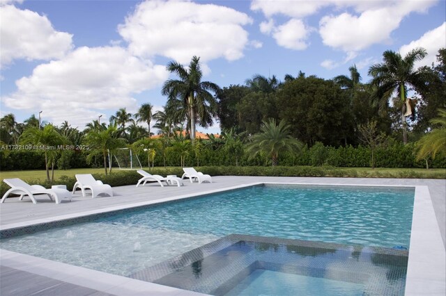 view of swimming pool with an in ground hot tub and a patio