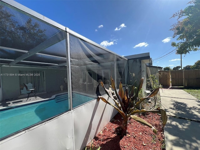 view of swimming pool with glass enclosure and a patio area