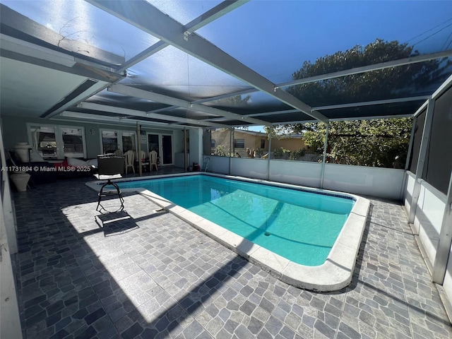 view of swimming pool featuring a patio and glass enclosure