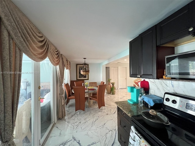 kitchen with dark stone countertops, pendant lighting, and appliances with stainless steel finishes