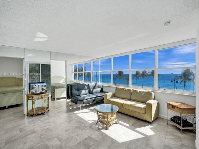 sunroom featuring a water view