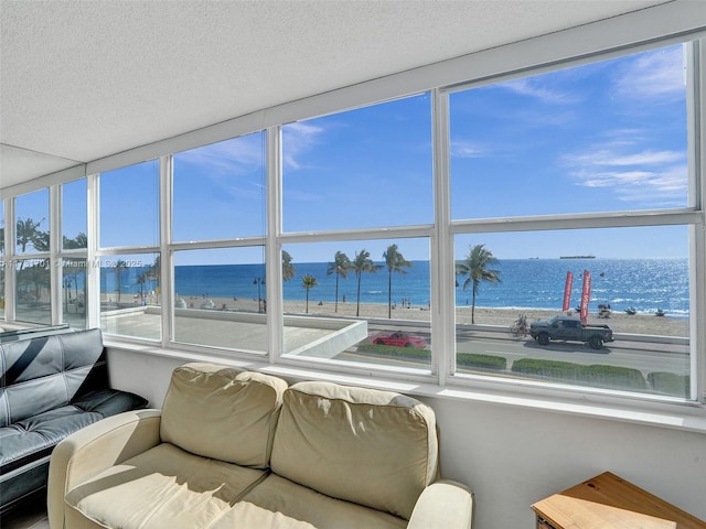 sunroom with a beach view and a water view