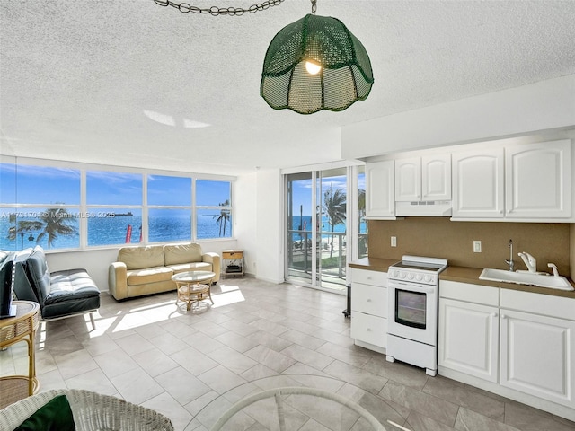 kitchen with white electric stove, sink, white cabinets, light tile patterned floors, and a water view