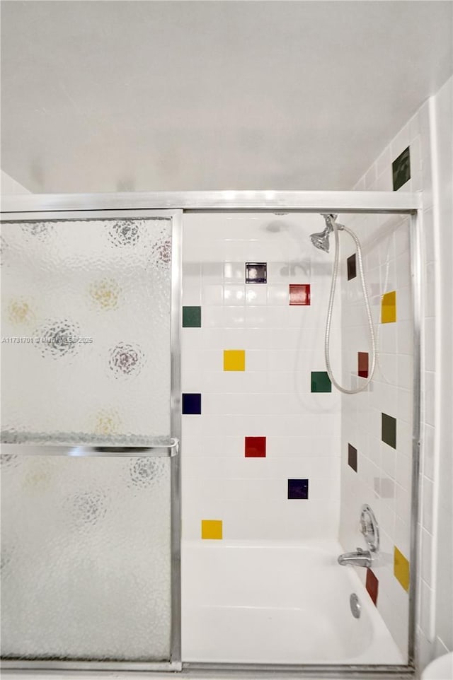 bathroom with shower / bath combination with glass door