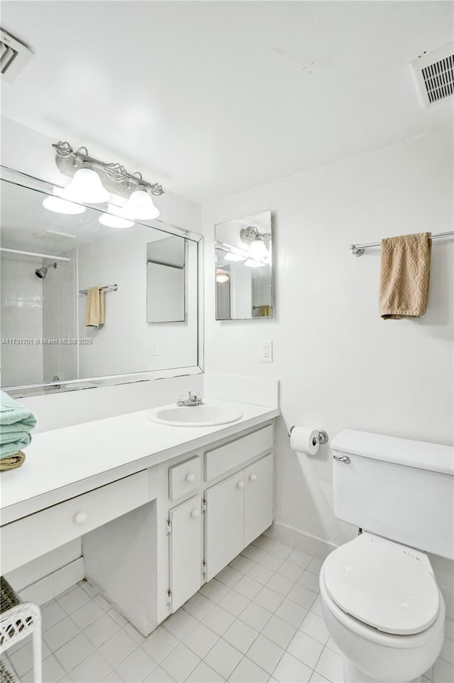 bathroom featuring vanity, walk in shower, tile patterned floors, and toilet