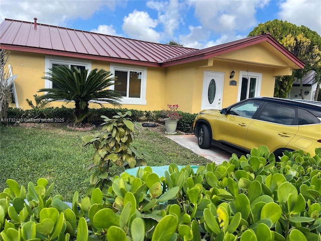 view of front of property with a standing seam roof, metal roof, and stucco siding